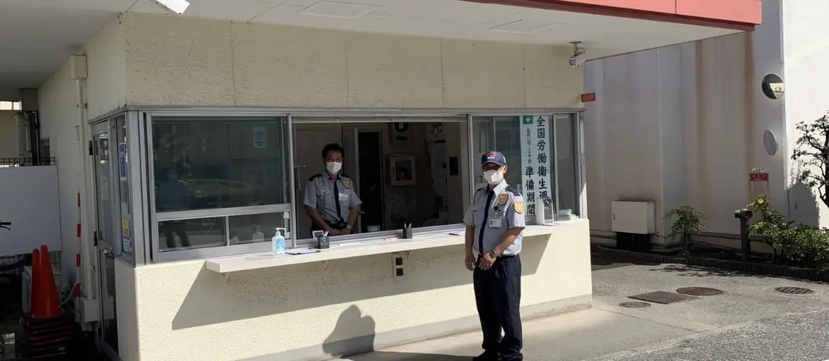 施設の入り口に立つ男性警備員